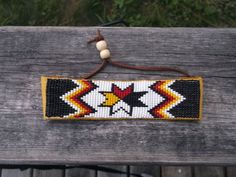 a wooden bench with a beaded bracelet on it's end and beads hanging from the back