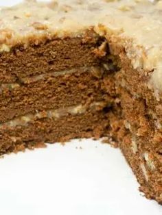 a chocolate cake with frosting and nuts on top is cut in half to show the inside