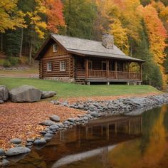 a log cabin sitting on top of a lush green hillside next to a lake and forest