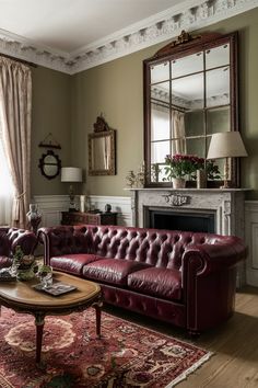 a living room with a red leather couch and mirror on the wall above it's fireplace