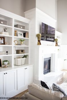 a living room with white bookcases and a fireplace