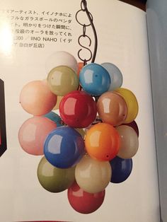 an open book with many balloons hanging from it's sides and in the middle