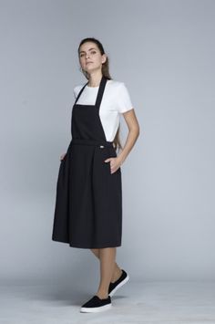 -Apron Wrap Dress ONA. Joint project of the UGi code team and designer Ieva Ševiakovaitė. A collection of clothing designed by the fashion designer under the UGi - UNIFORM by IEVA label. We are delighted to be able to offer you and your team products designed and made in Lithuania with love and care, down to the very last seam. -Base colour of the model is black. -One size fits all.  -Composition - 78% polyester, 17% viscose, 5% spandex. -The density of fabric - 195 g/m². -Designed and manufactured in Lithuania. Spring Black Pinafore Dress For Work, Black Spring Pinafore Dress For Work, Black Workwear Dress With Pockets, Black Dress With Pockets For Work, Modern Black Dresses For Work, Handmade Aprons, Uniform Fashion, Apron Dress, Office Outfits