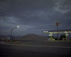 an empty gas station at night with the lights on