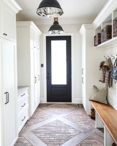 an instagram page with a black door and white cabinets in the hallway, next to a wooden bench