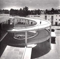 the circular building is surrounded by buildings and trees