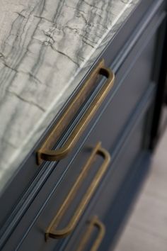 an image of a black and gold dresser with handles on the bottom, which is open