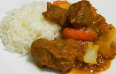 a white plate topped with meat and rice