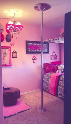 a bedroom with pink walls and pictures on the wall, including a floor lamp in the corner