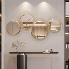 an elegant console with three circular mirrors on the wall