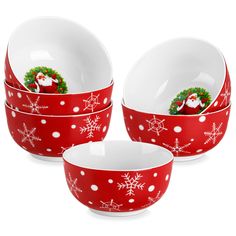 three red and white christmas dishes with santa clause on the front, snowflakes around them