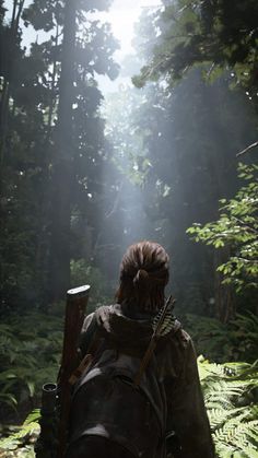 a person walking through the woods with a backpack on their back and sunbeams in the background