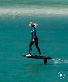 a woman is standing on a surfboard in the water