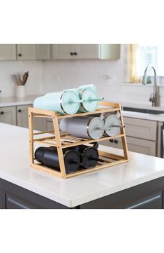 a kitchen island with plates and cups stacked on top of it in front of the sink