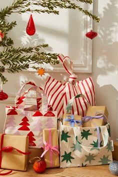 christmas presents sitting on the floor next to a tree