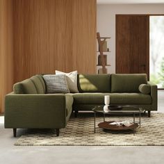 a living room with a sectional couch and coffee table in it's center area