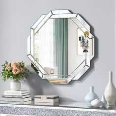 a mirror sitting on top of a mantle next to a vase