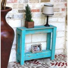 a blue table with a potted plant on top and a photo frame in front