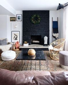 a living room filled with furniture and a fire place in front of a brick wall