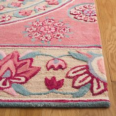 a pink and blue rug with flowers on it