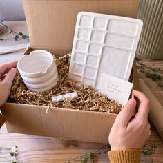 a person is opening a box with an ice cream container in it and there are other items inside the box