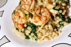 a white plate topped with pasta and shrimp