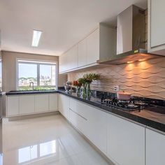 a large kitchen with white cabinets and black counter tops on the walls, along with an island in the middle