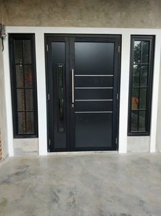 the front door is painted black and has two sidelights on either side of it