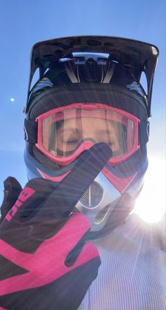 a person with goggles and skis on is holding up their helmet to the camera