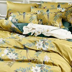 a bed covered in yellow and green comforters