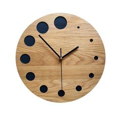 a wooden clock with black dots on it