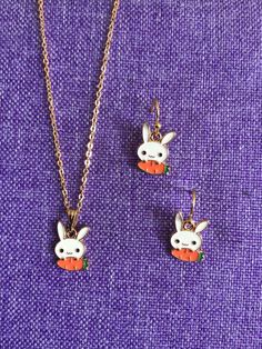 two necklaces with cartoon characters on them sitting next to each other, one has a carrot in the shape of a bunny