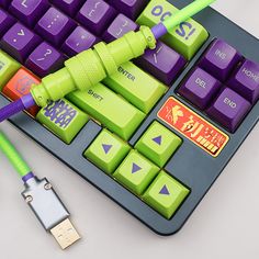 a purple keyboard with green keys on it and a yellow cord attached to the key board