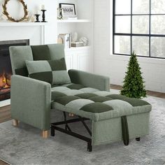 a living room with a green chair and ottoman in front of a fire place that has a christmas tree on it