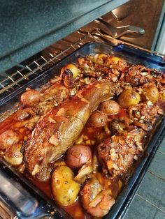 a pan filled with meat and potatoes on top of an oven