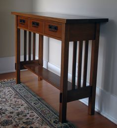 a wooden table with two drawers and a rug on the floor