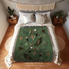 a bed covered in a green blanket with birds on it