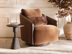 a brown chair sitting on top of a rug next to a table