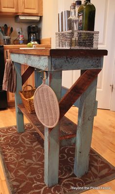 a kitchen island made out of an old table and some baskets on the top shelf