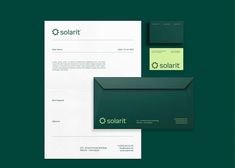 some green and white stationery items on a dark green background with the word solart