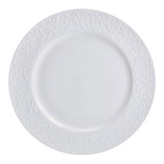 a white plate with an intricate design on the rim and bottom, is shown against a white background