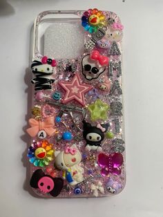 a cell phone case with many different items on the front and back cover, all covered in sequins