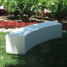 a white bench sitting on top of a lush green field