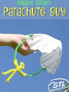 a hand holding a coffee filter parachute toy with the words coffee filter parachute guy on it