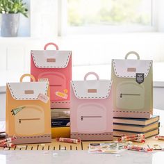 a person holding a small pink and yellow bag next to other bags on a table