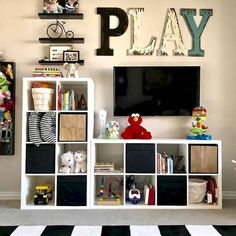 a playroom with toys, bookshelves and a television mounted on the wall