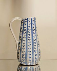 a blue and white pitcher sitting on top of a table