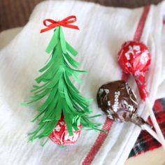 a paper christmas tree sitting on top of a table next to chocolate covered candies