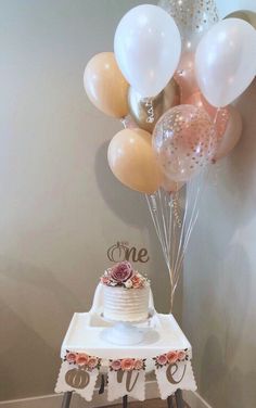 a table with a cake and balloons on it