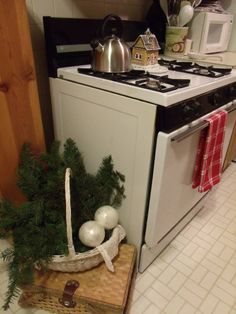 a stove top oven sitting inside of a kitchen next to a christmas decoration on the counter